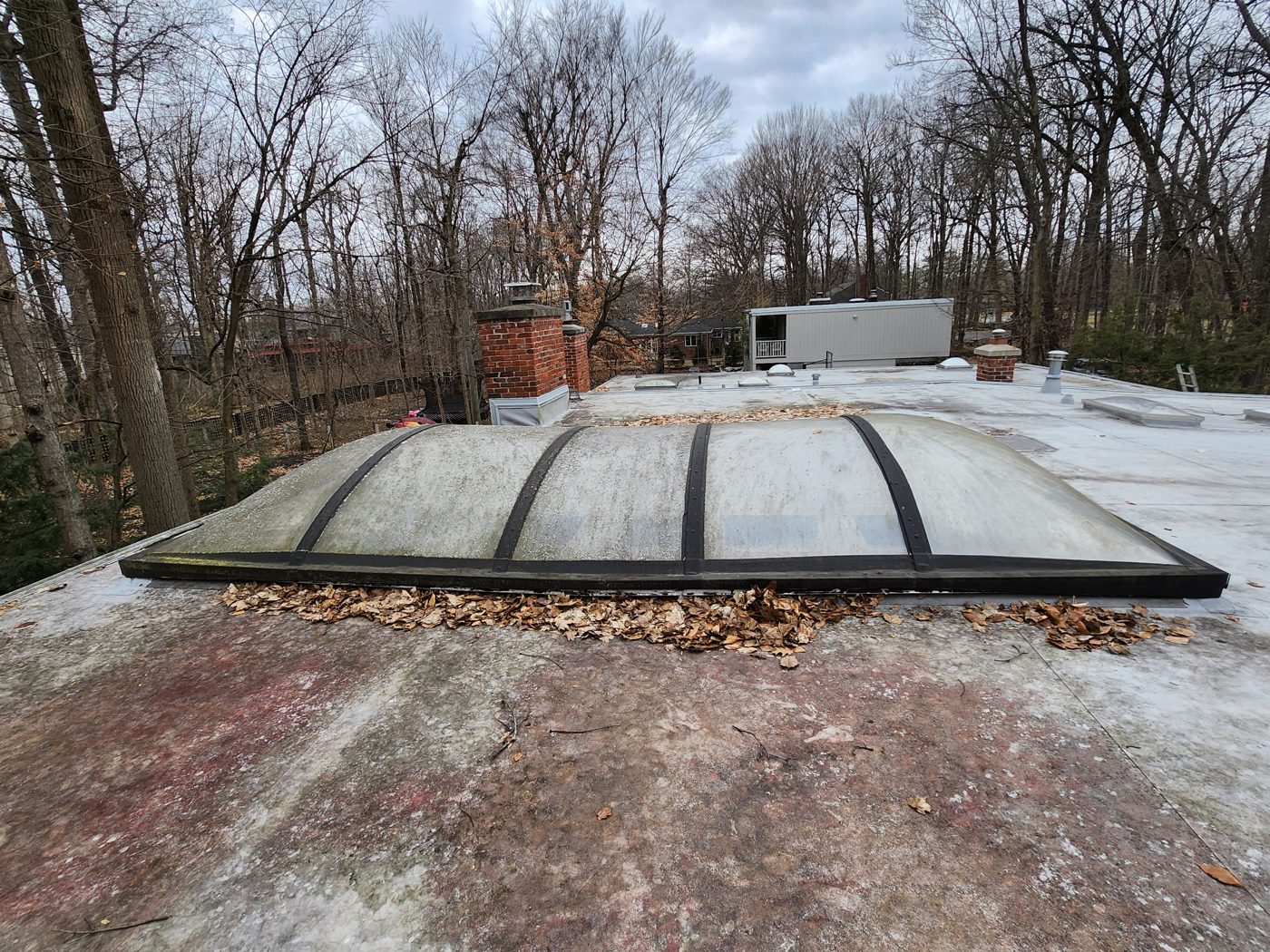 Worn flat roof with aged membrane before replacement